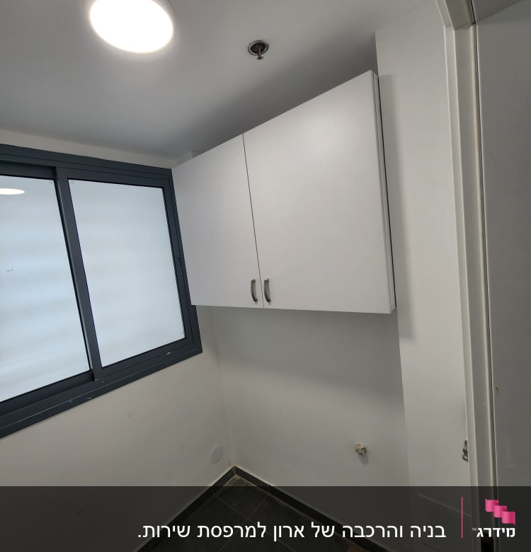 ארון קיר לבן מותקן על קיר בחדר